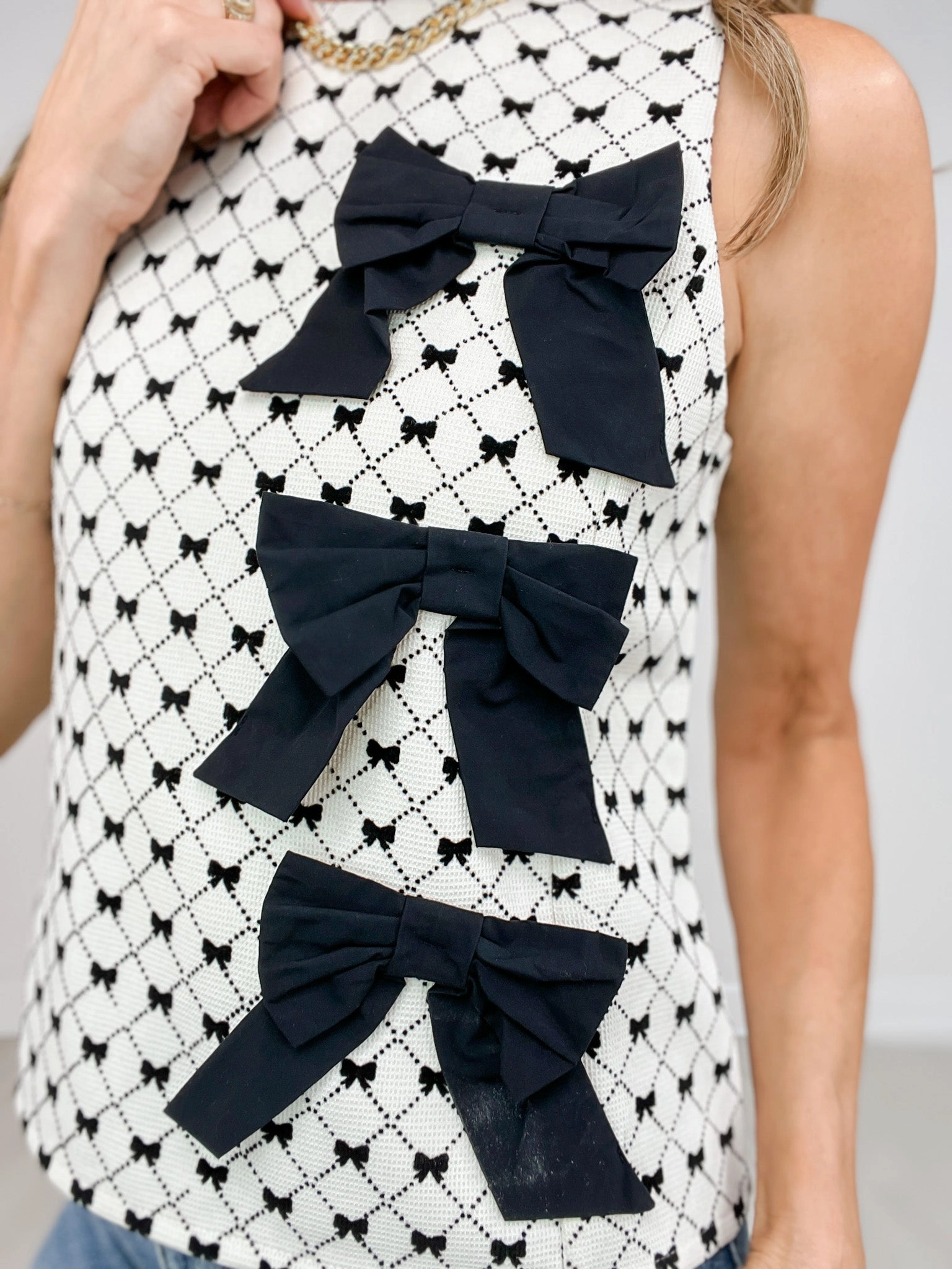 LowMaintenanceMaterial Bow Textured Woven Sleeveless Top With Bow Appliques